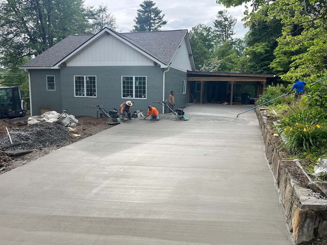 Crew finishing a fresh concrete driveway